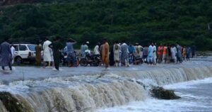 People gather at a flooded area in Gilgit