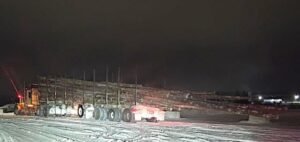 Logs hanging off back of truck ends with charges for driver, company